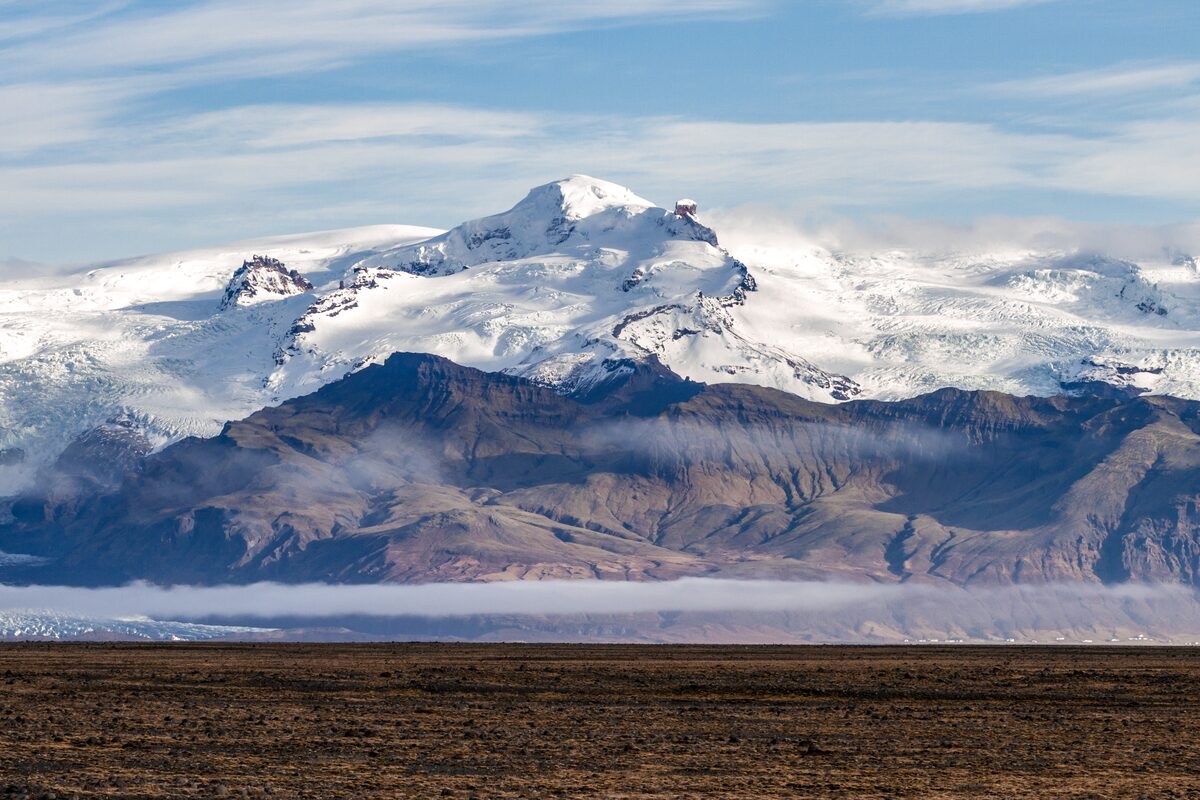 View of large mountain Hvannadalshnukur in distance covered in snow 