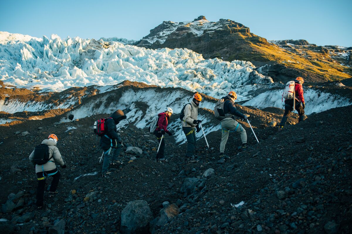 Hikers at Falljokull walking across volcanic ash to get to glacier 