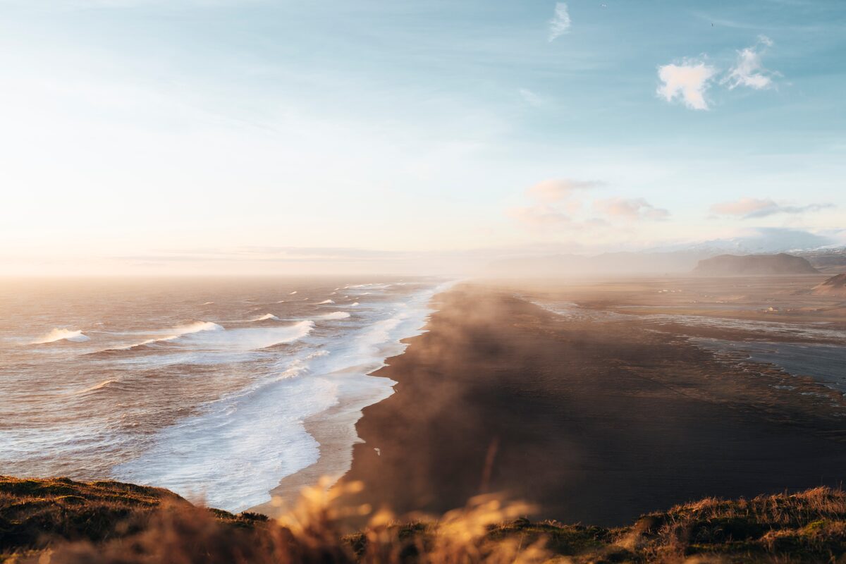 Icelandic black beach during summer time with golden rays 