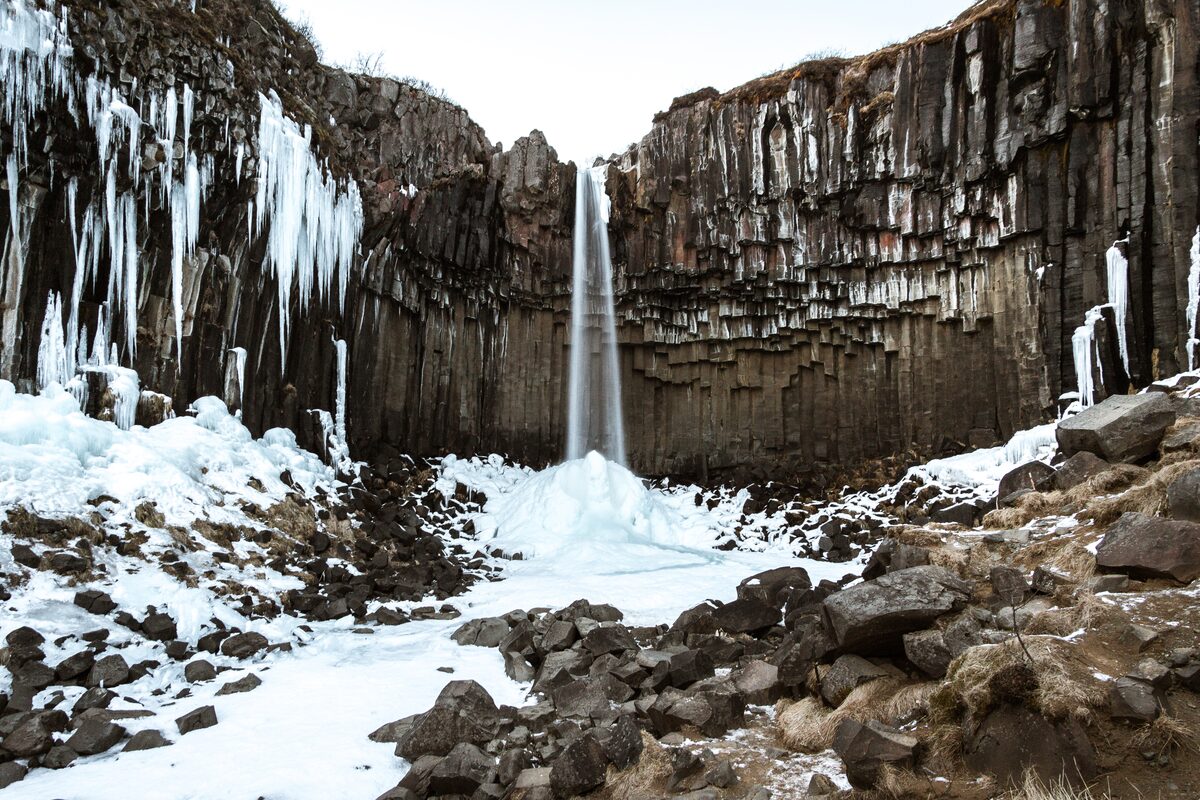 Svartifoss waterfall during winter months covered in snow and ice