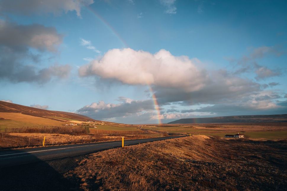 Driving road in north Iceland close to Godafoss with rainbow