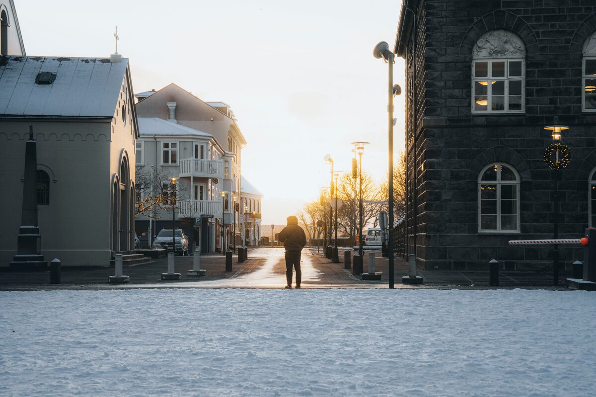 Man standing towards sunset in street in Reykjavik between city buildings