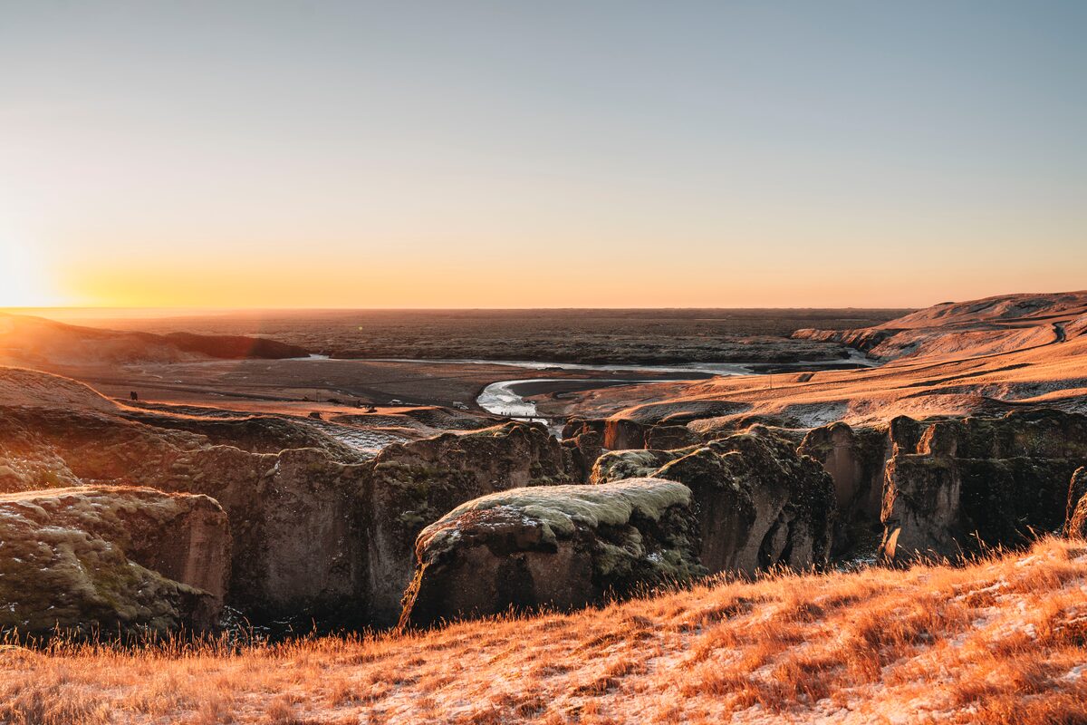 Top of Fjardargljufur canyon early sun rise and frosty covered Spring grass.
