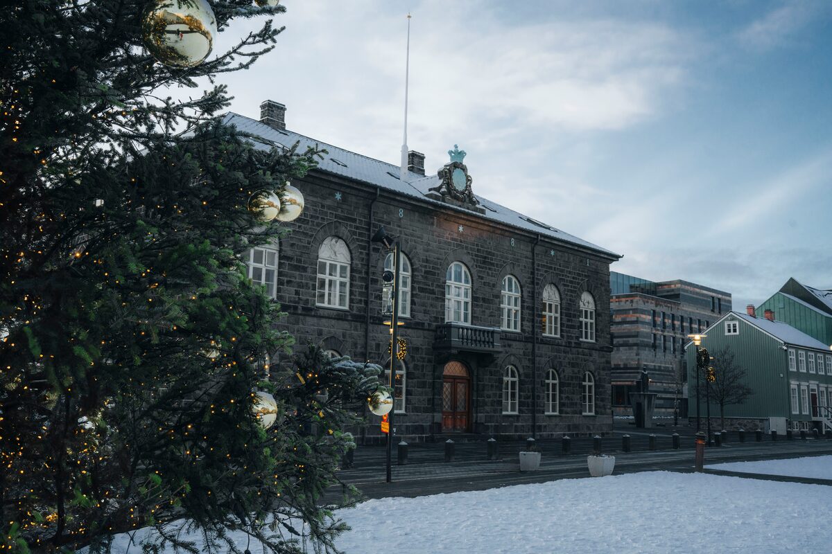 Christmas tree next to parliament building in Reykjavik city center during winter.