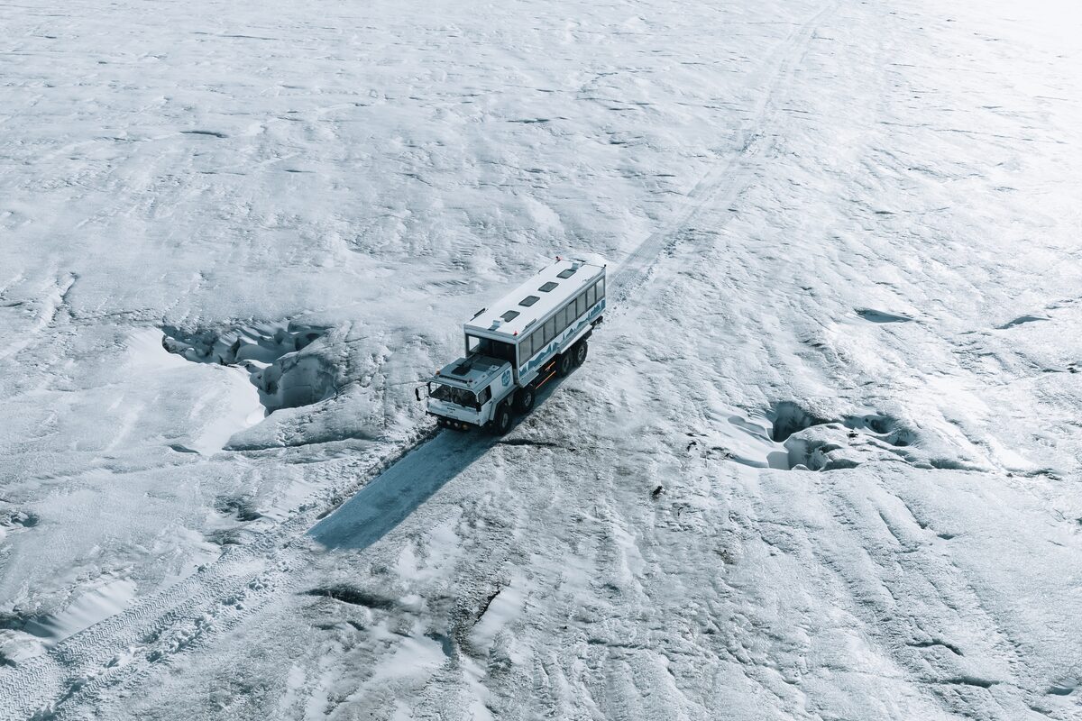 Glacier truck driving through snow covered field at Langjoukll glacier.