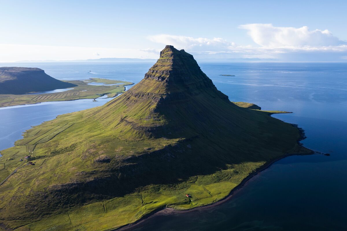 Birds eye view of green mount Kirkjufell with deep blue skies.