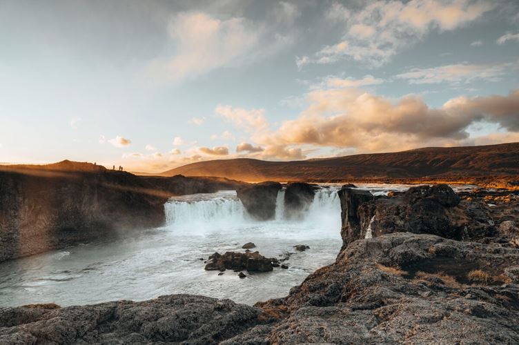 Grand Godafoss falls during a sunset in north Iceland silhouettes of people in distance.