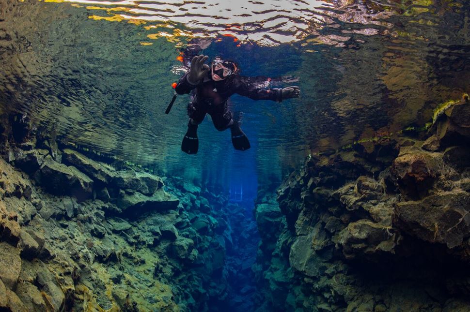 Female snorkeling underwater at Silfra Fissure between two tectonic plates.