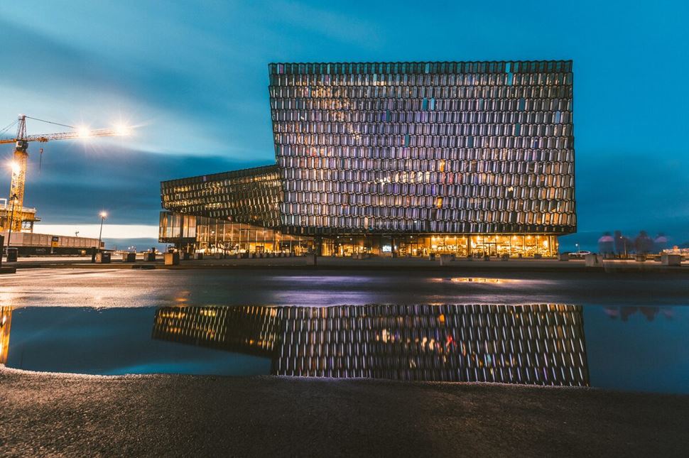 Harpa concery hall with lights shining in night sky, Reykjavik.
