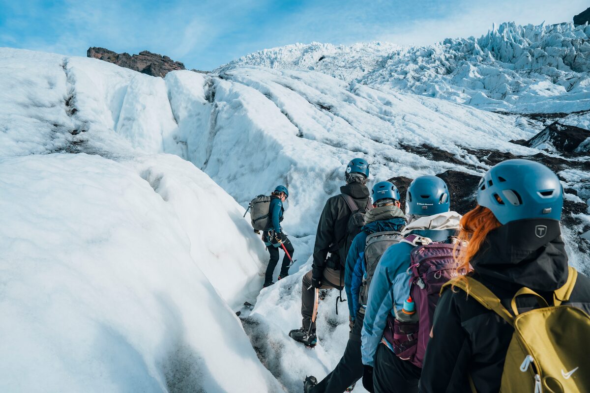 View from behind a small glacier group of people hiking Vatnajokull glacier.