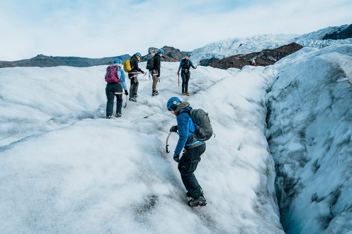Small group walking across steep ice crevasse at Vatnajokull.
