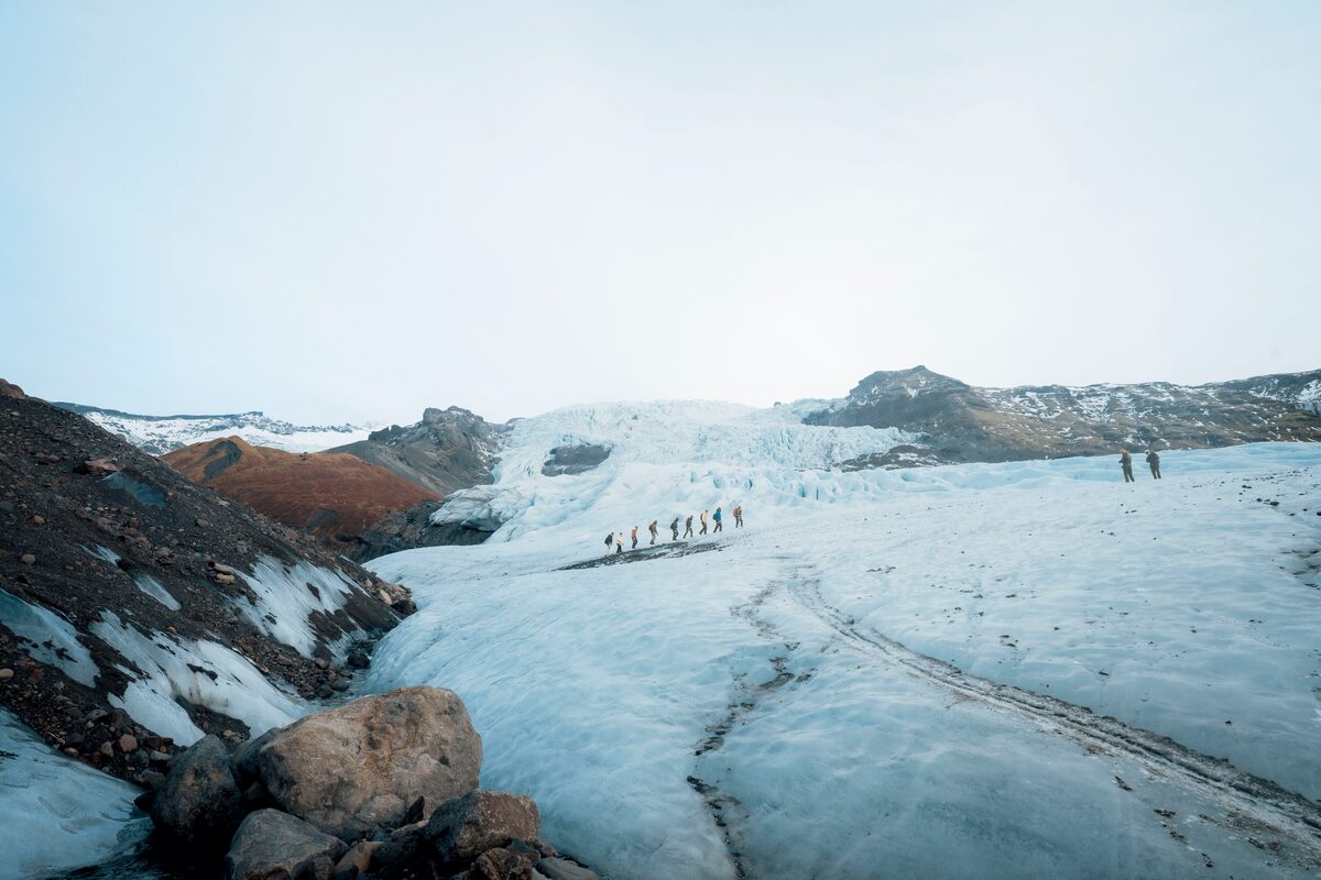Wide landscape view of small hiking group in distance at Vatnajokull glacier.