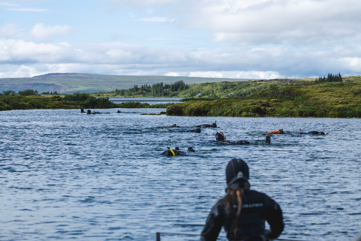 Above waters at Silfra Fissure, small group exploring waters and snorkeling in summer.