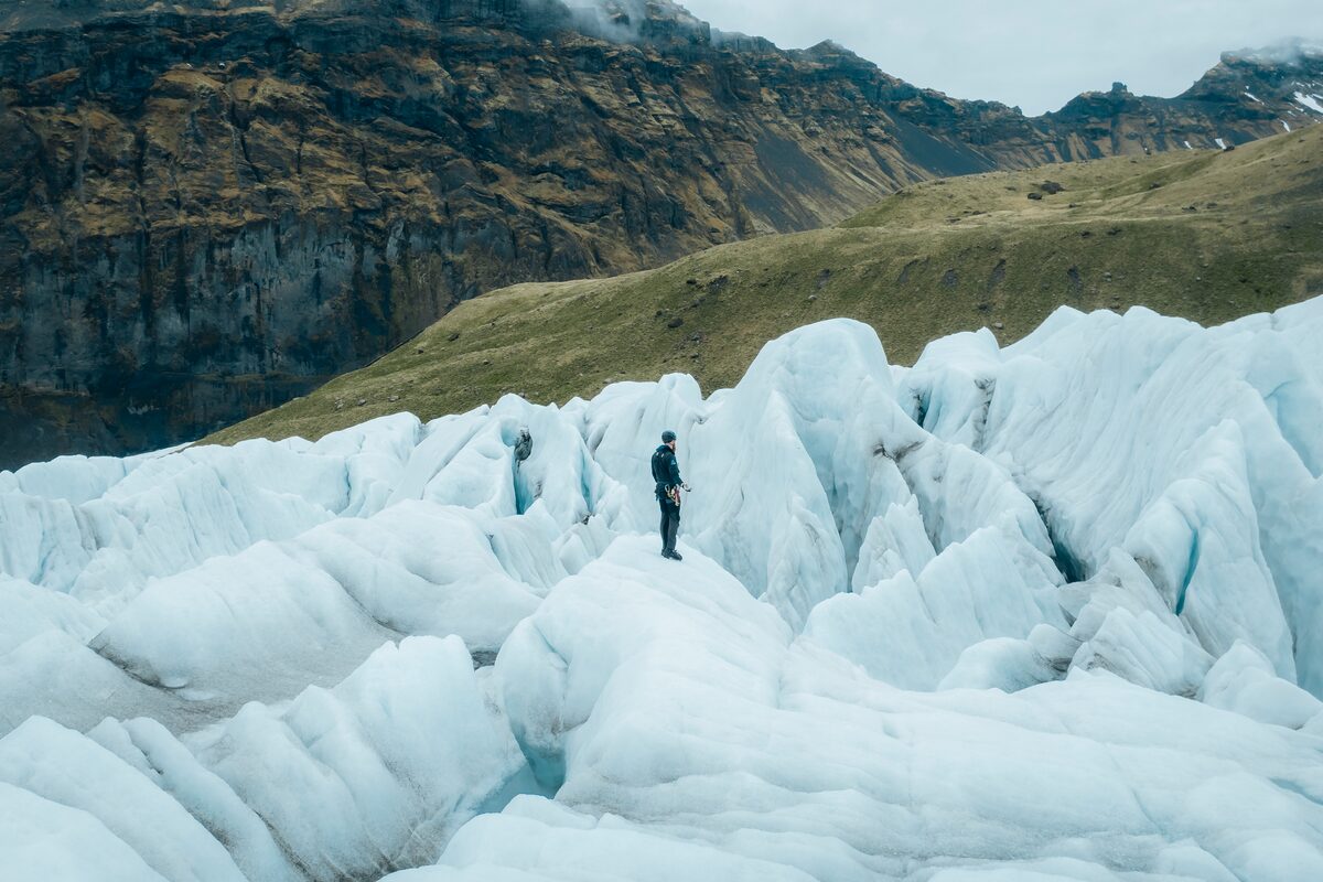 Tour guide hiking through glacier ice crevasse maze at Falljokull glacier.