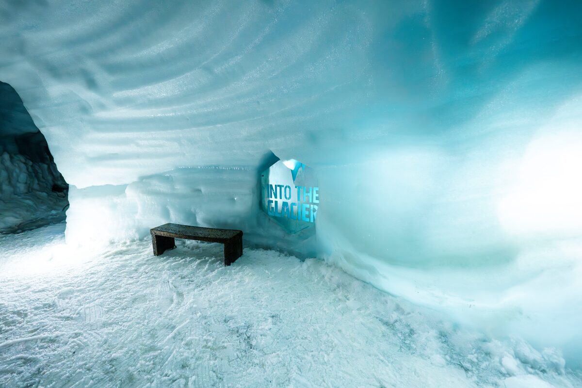 Blue light 'into the glacier' sign inside Langjokull ice tunnel in Iceland.