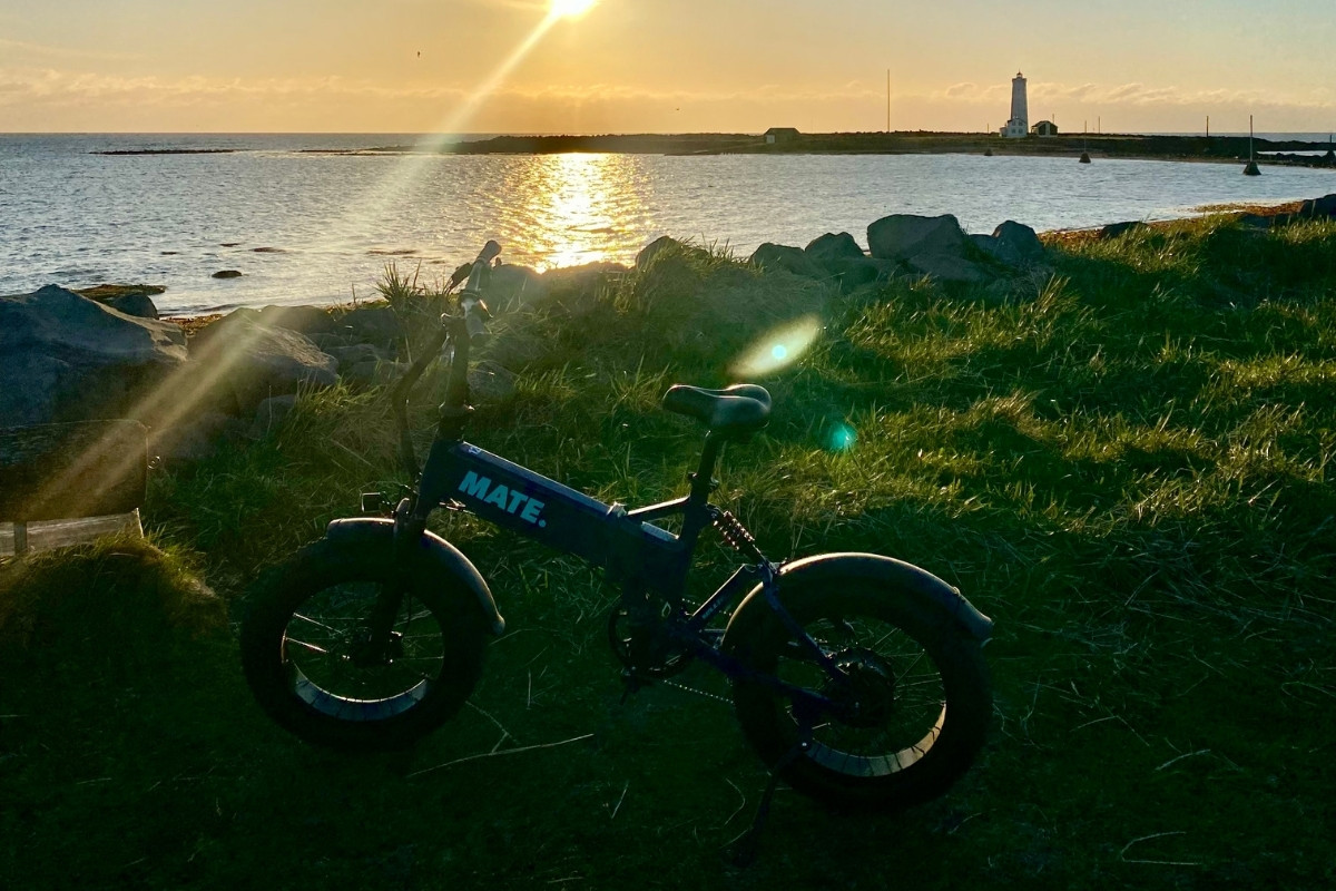 Electric bike on green grass after sun has set at Nautholsvik Lighthouse.