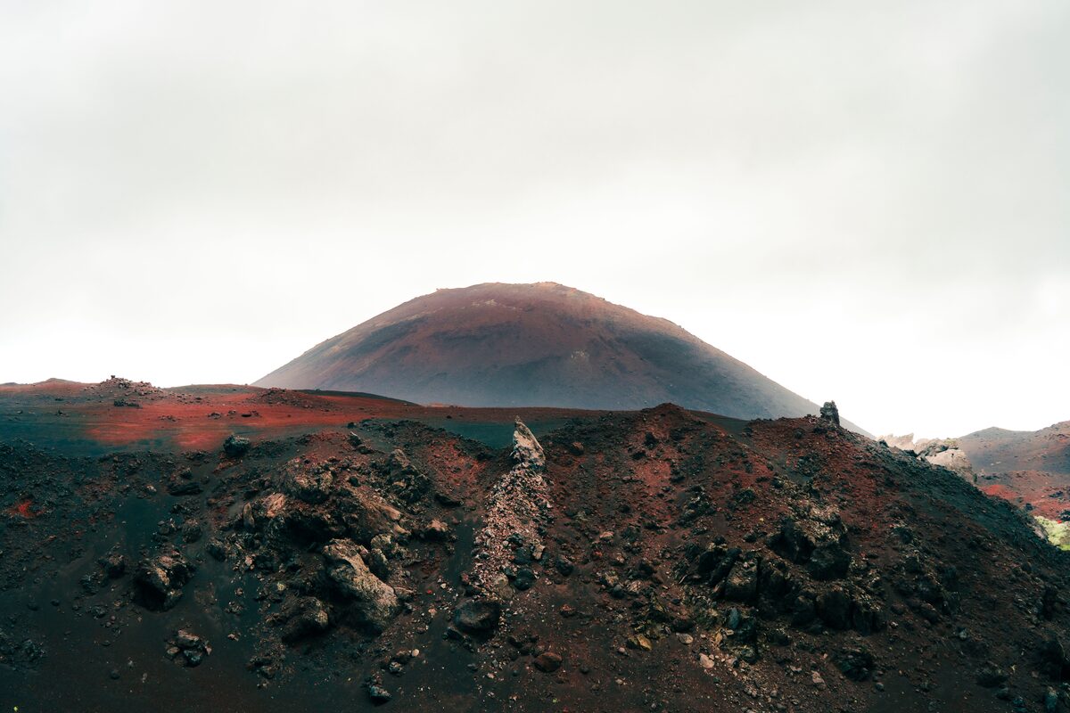 Red ash and dirt covered Heimaey island volcano.