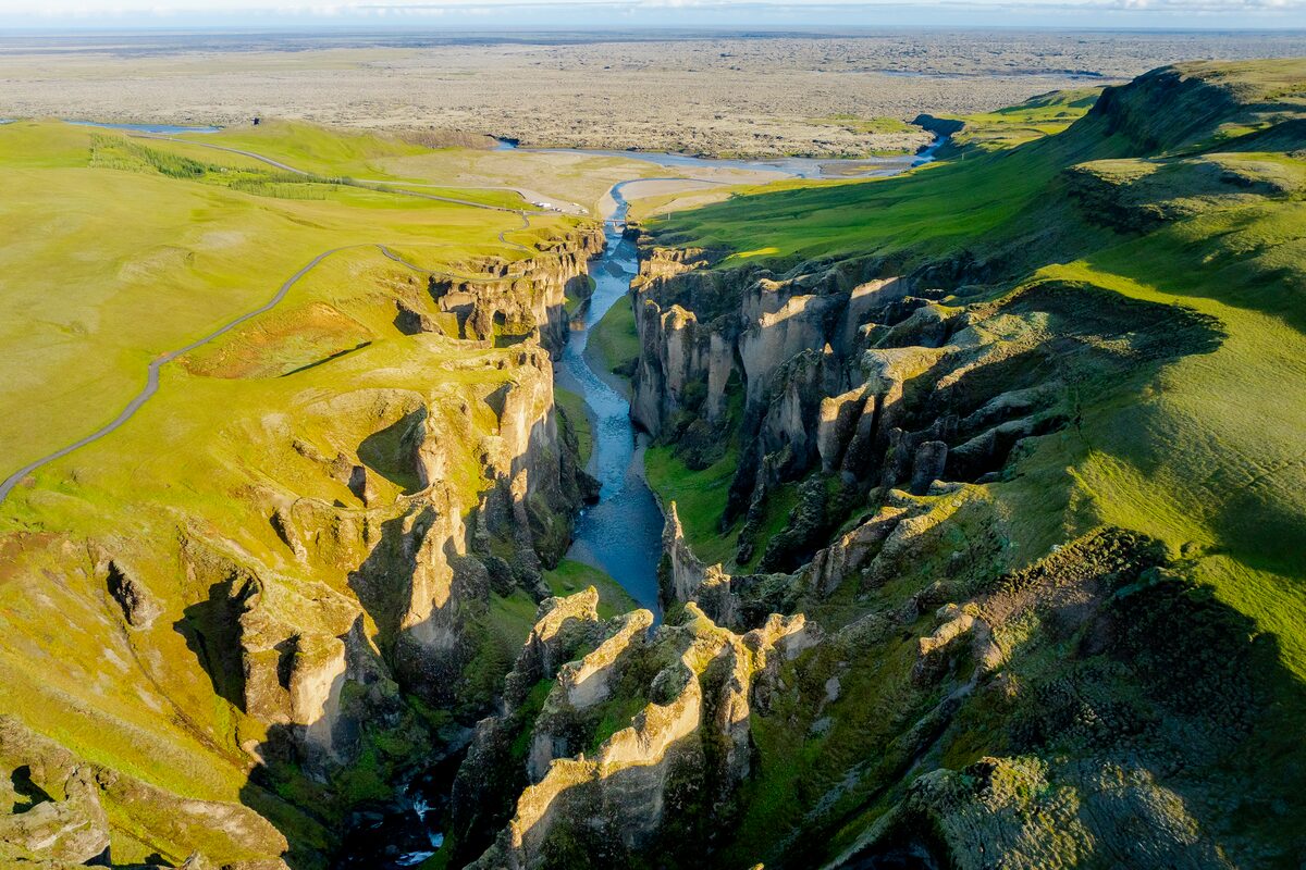 Moss covered Fjadrargljufur canyon with large stream running inbetween in summer months in Iceland.