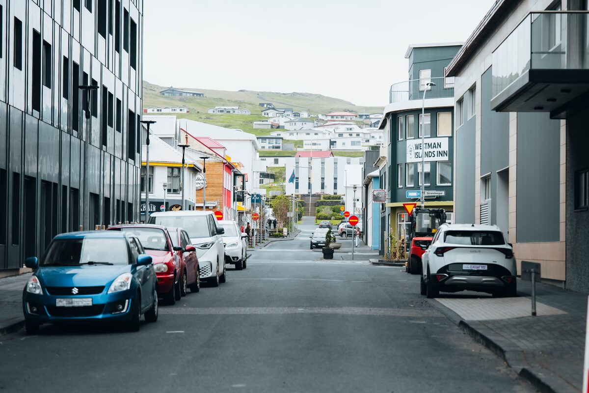 Quiet streets on Westman Island lined with colorful houses and parked cars, leading toward the Westmann Inn.