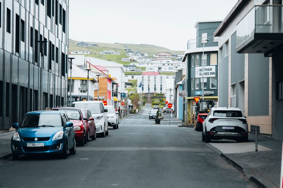 Quiet streets on Westman Island lined with colorful houses and parked cars, leading toward the Westmann Inn.