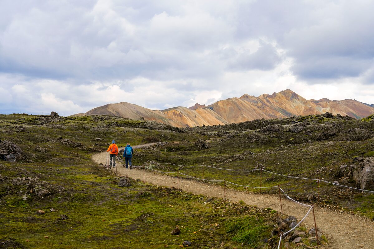 Two tourists hiking through geothermal field at Landmannalaugar.