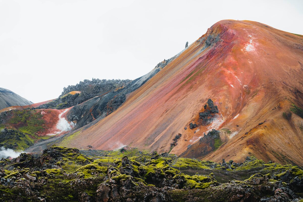 Colorful mountains red, blue and yellow earth and moss covered geothermal field.