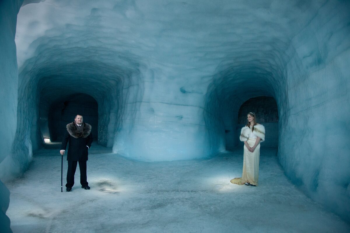 Couple inside Langjokull glacier ice tunnel, taking photos for wedding shoot.