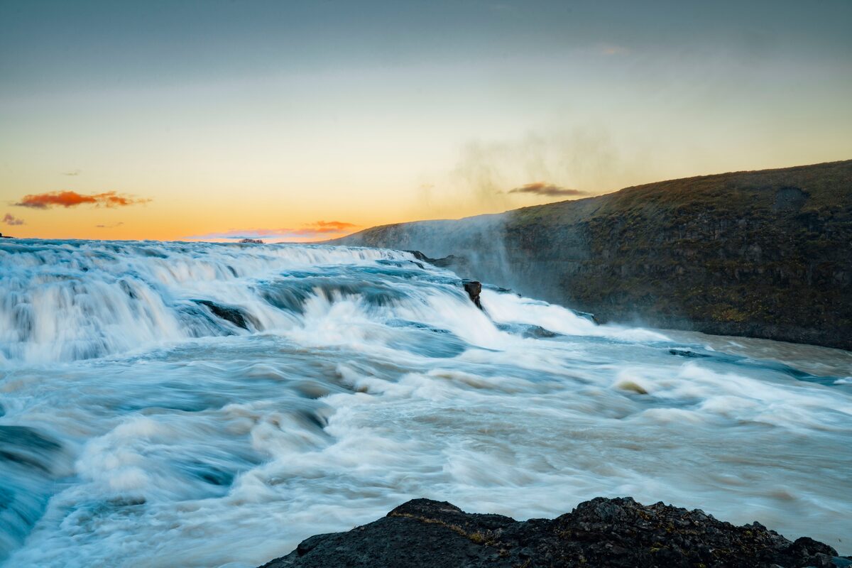 Close up of crashing Gullfoss waterfall in autumn, during a golden sunset.
