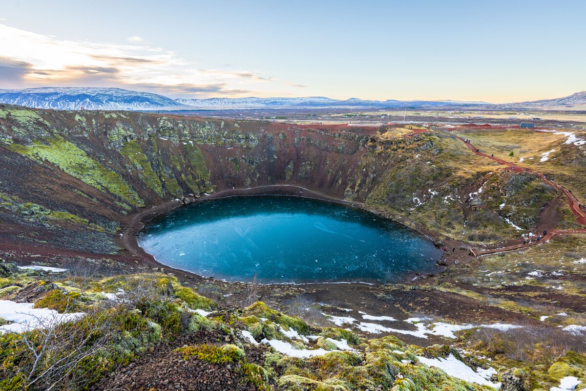Landscape view of the deep blue crater lake that sits inside Kerid volcanic crater during winter.