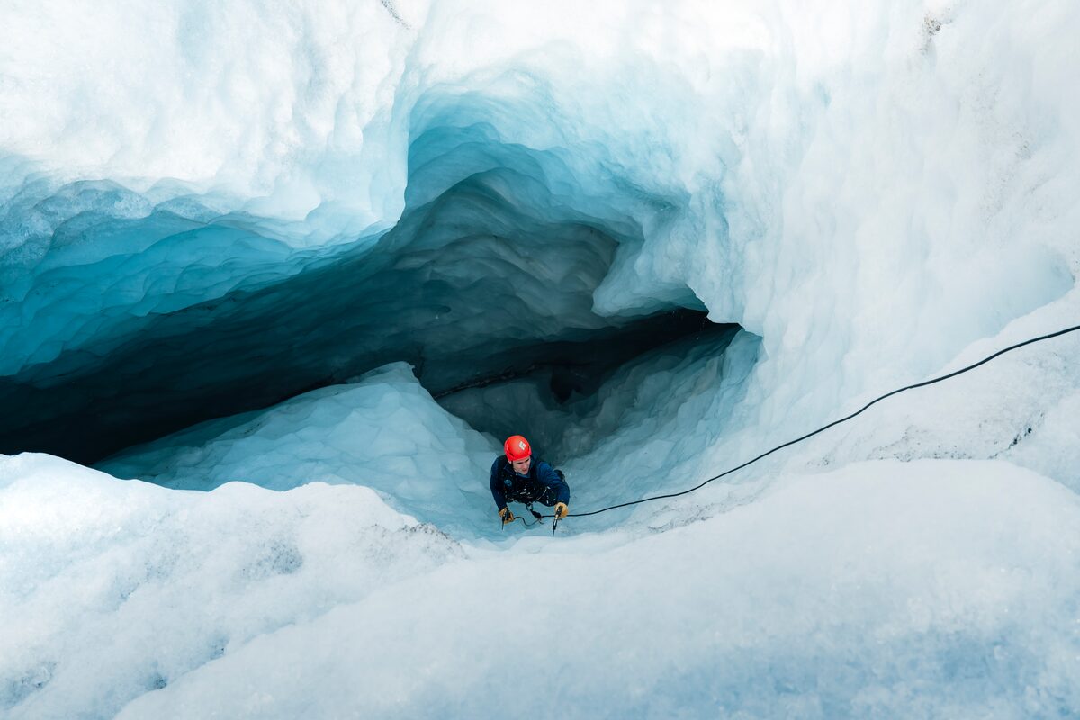 Man With A Red Helmet Ice Climbing On A Glacier in iceland