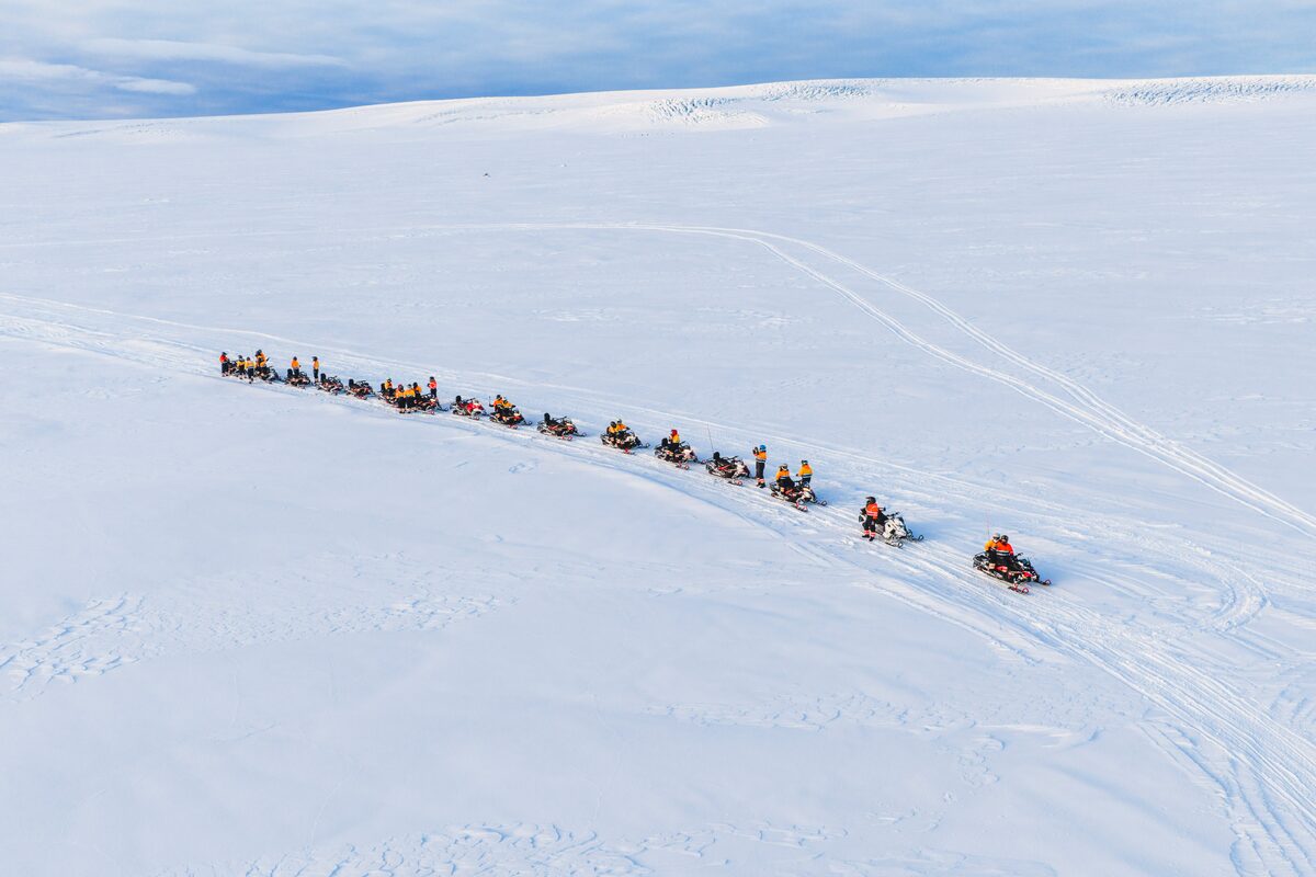 Snowmobiling Tour In Prigress Snowmobiles Lined Up On A Glacier in iceland