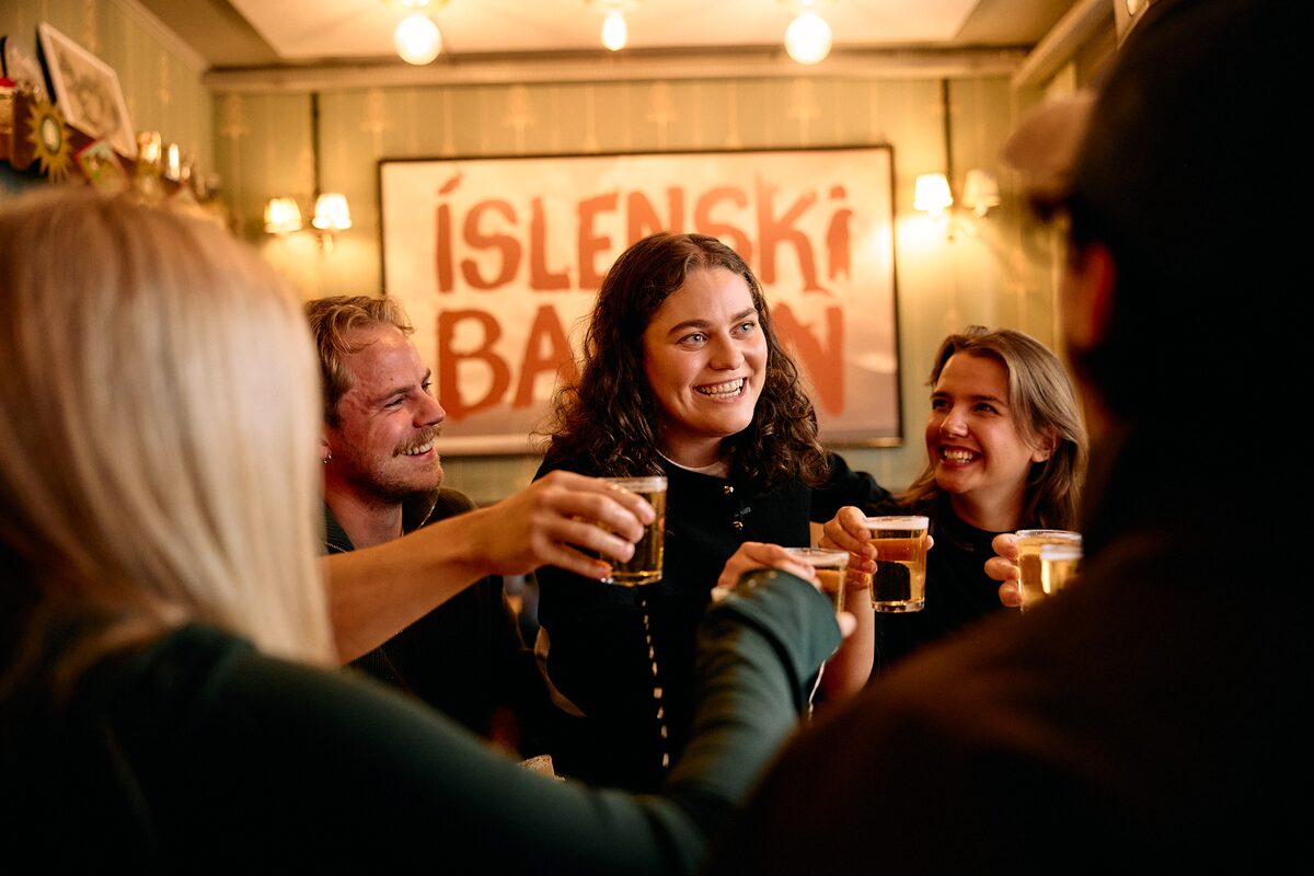 Close up view of group of friends with Icelandic beers in a bar in Reykjavik.