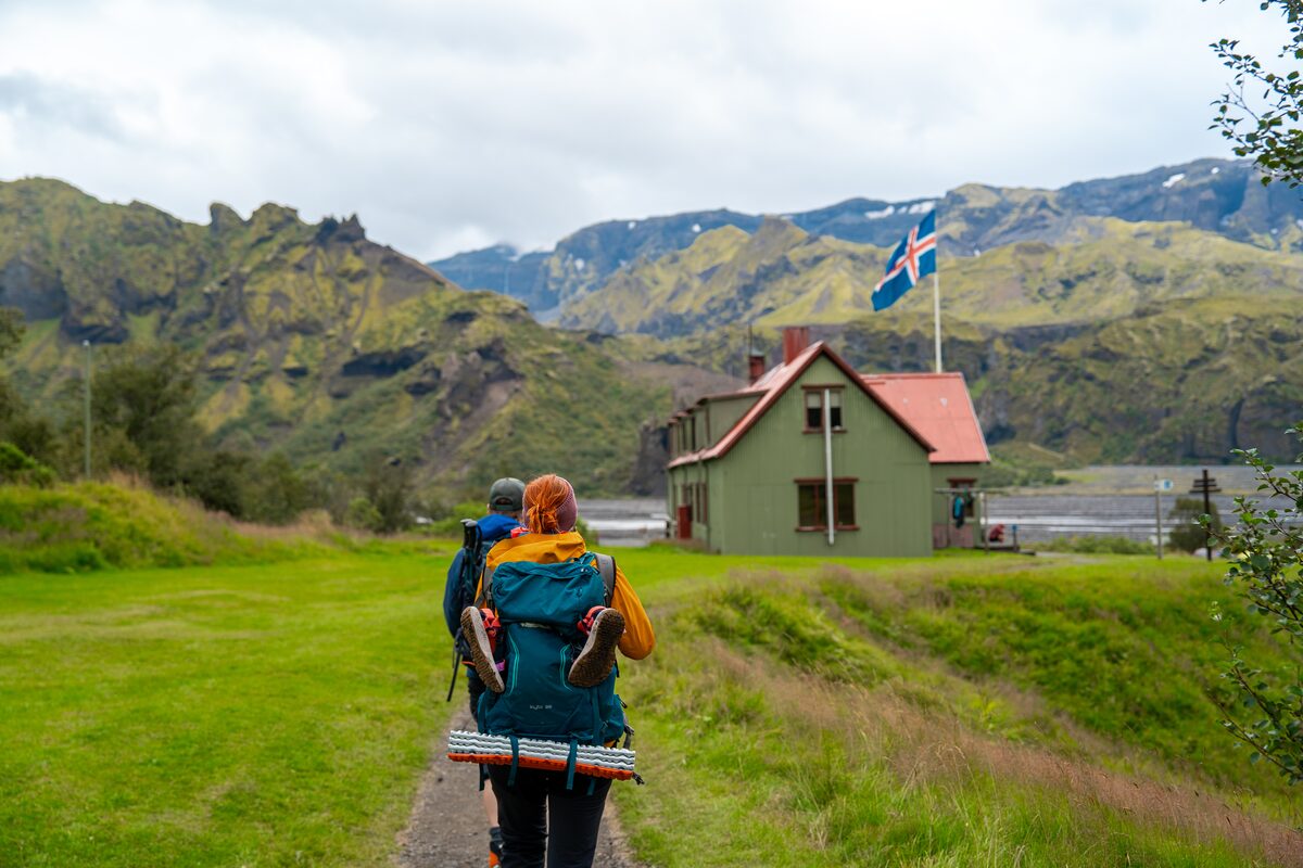 Female hiker walking towards a camping hut in the Laugavegur trail in Iceland.