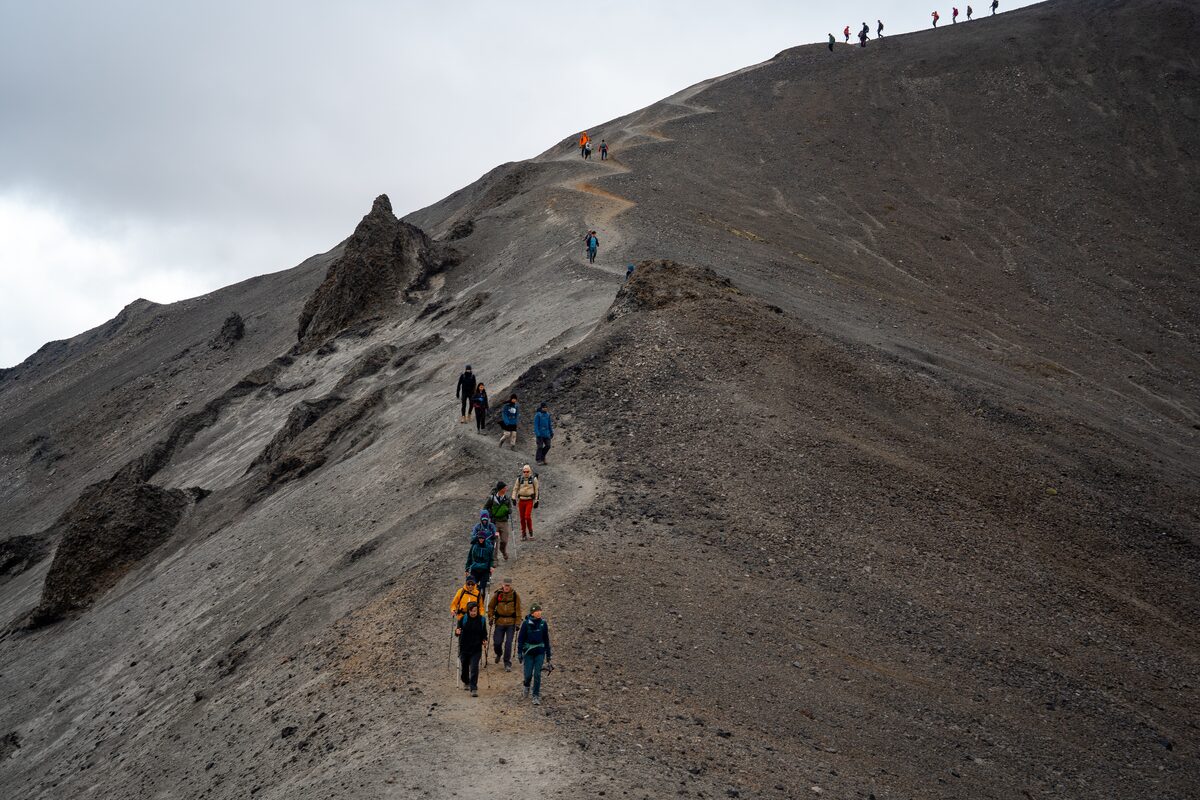 Group walking up steep jagged footpath up a mountain on Laugavegur trail.