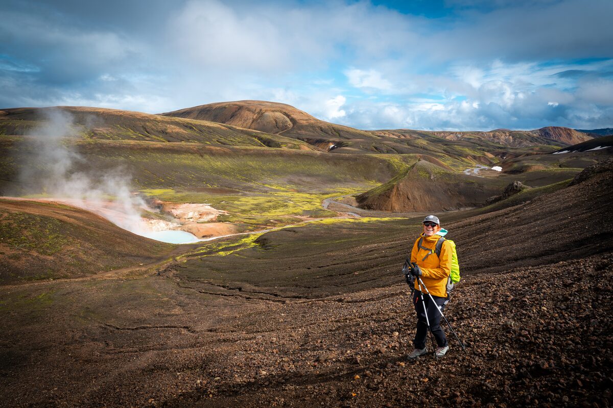 Female smiling posing next to geothermal area at Laugavegur, highlands in Iceland.