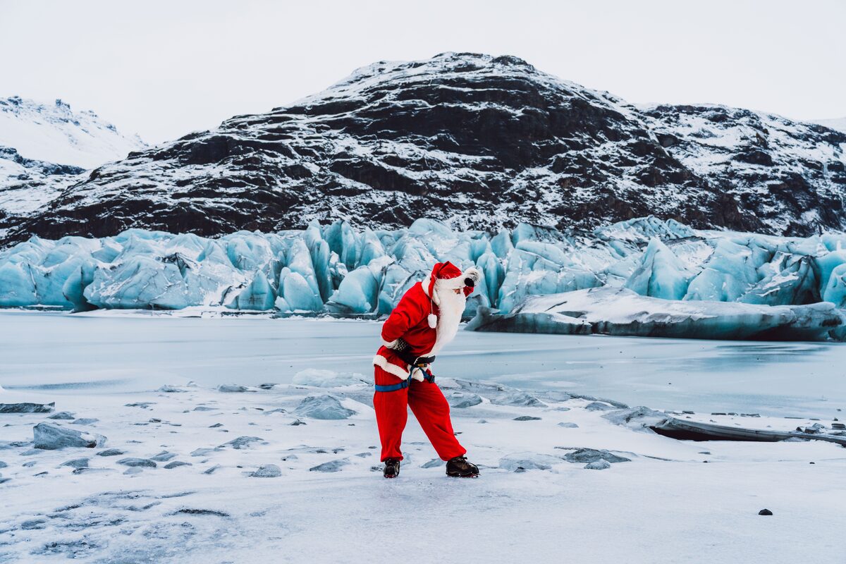 Santa posing for photograph on Solheimajokull glacier in Iceland.