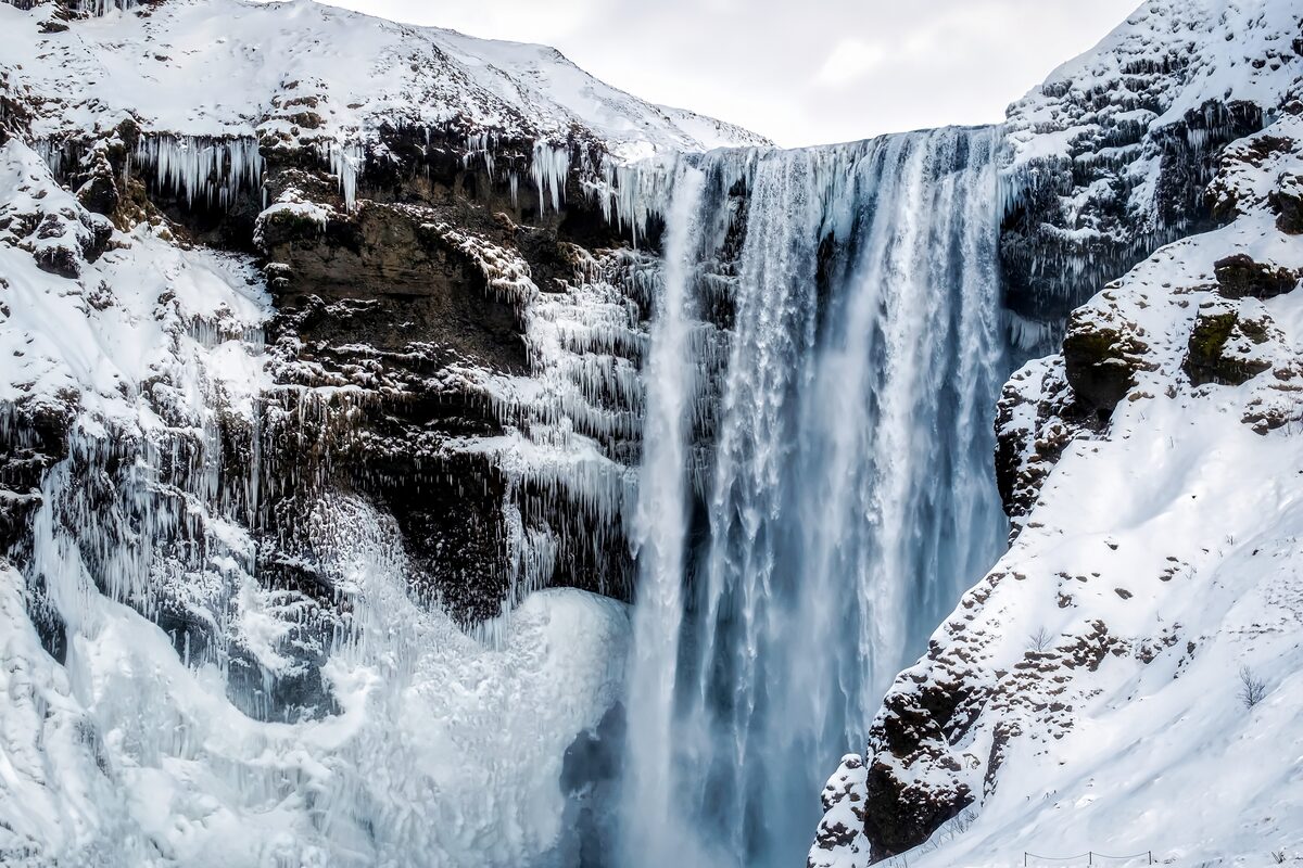 Close up view of Solheimajokull winter waterfall in Iceland during heavy snow.