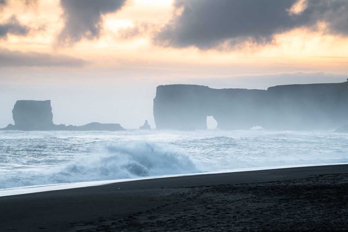 Landscape view of Reynisfjara black sand beach in Iceland during sunset.
