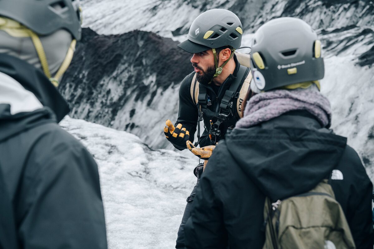 Close up view of glacier hike guide instructing on glacier hike tour at Solheimajokull glacier in winter.