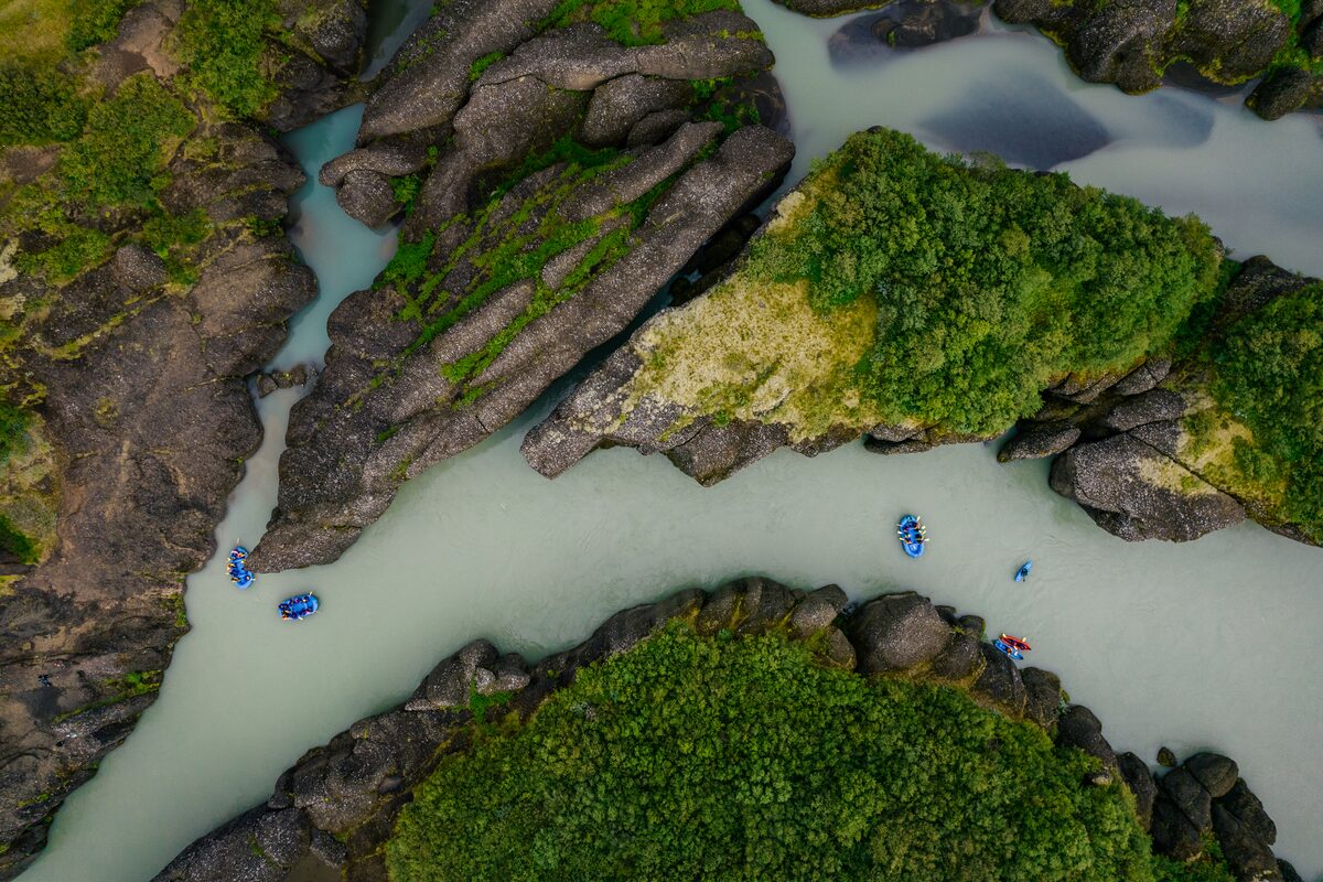 Aerial view of small groups of tourists rafting in Hvita river in Iceland.