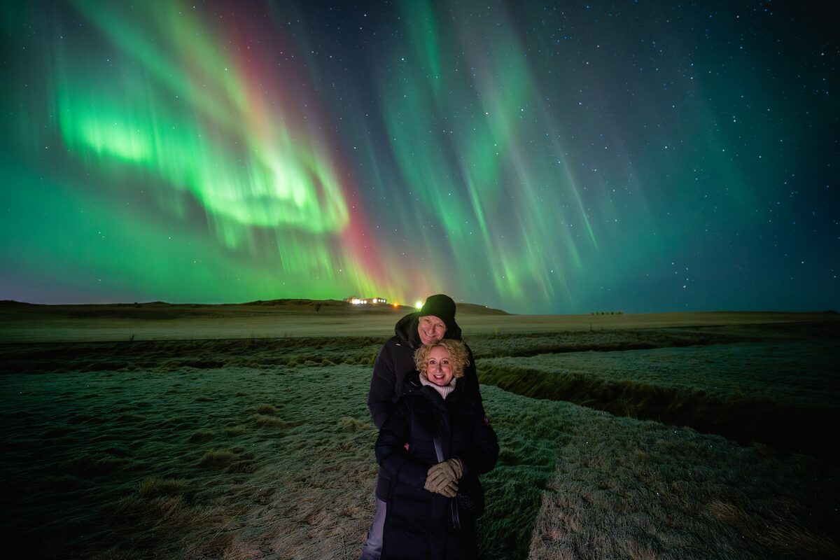 Couple Hugging And Posing Under Northern Lights in iceland
