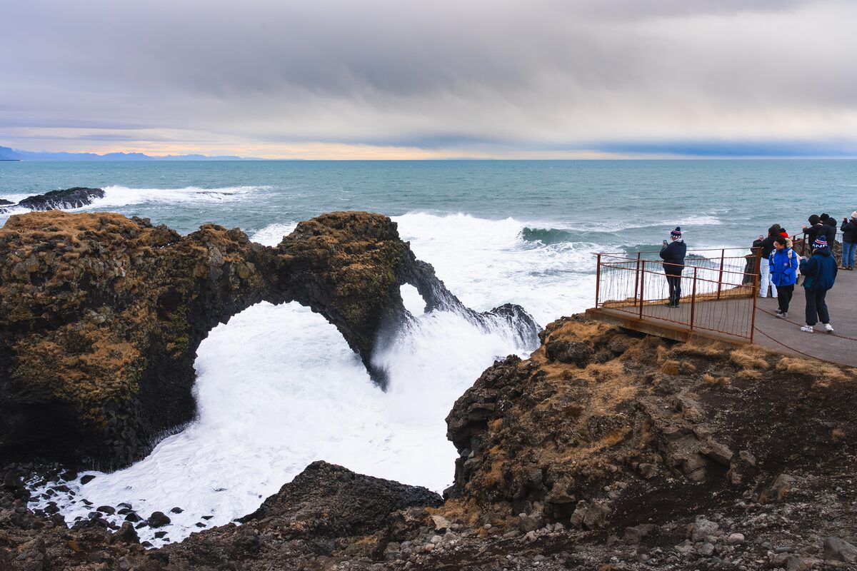 People Looking At Gatklettur in iceland