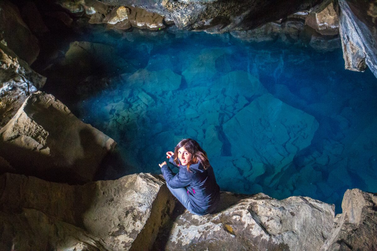 Woman Looking Up In Grjotagja Cave in iceland