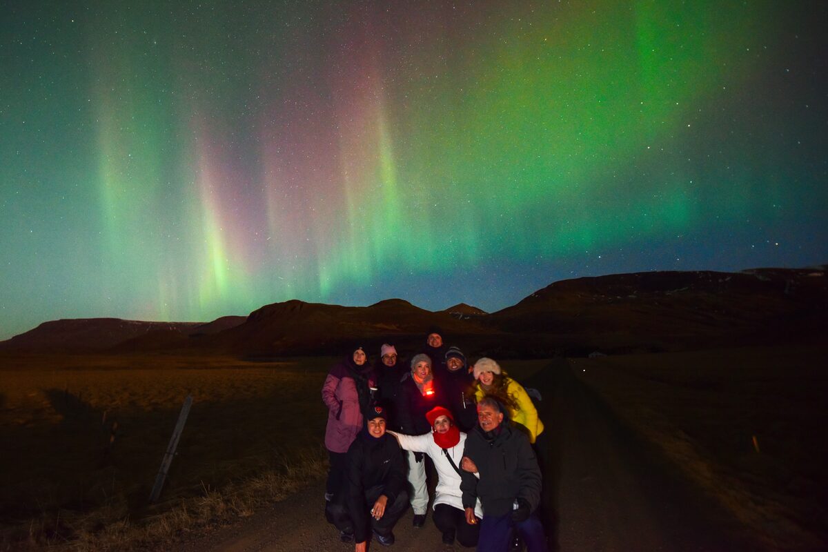 A Group Of People Under Northern Lights in iceland