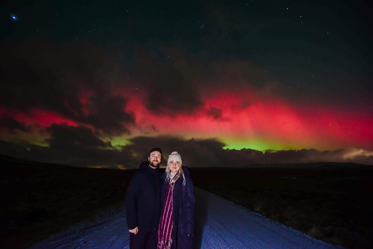 Couple In Front Of Aurora Borealis Painted Sky in iceland
