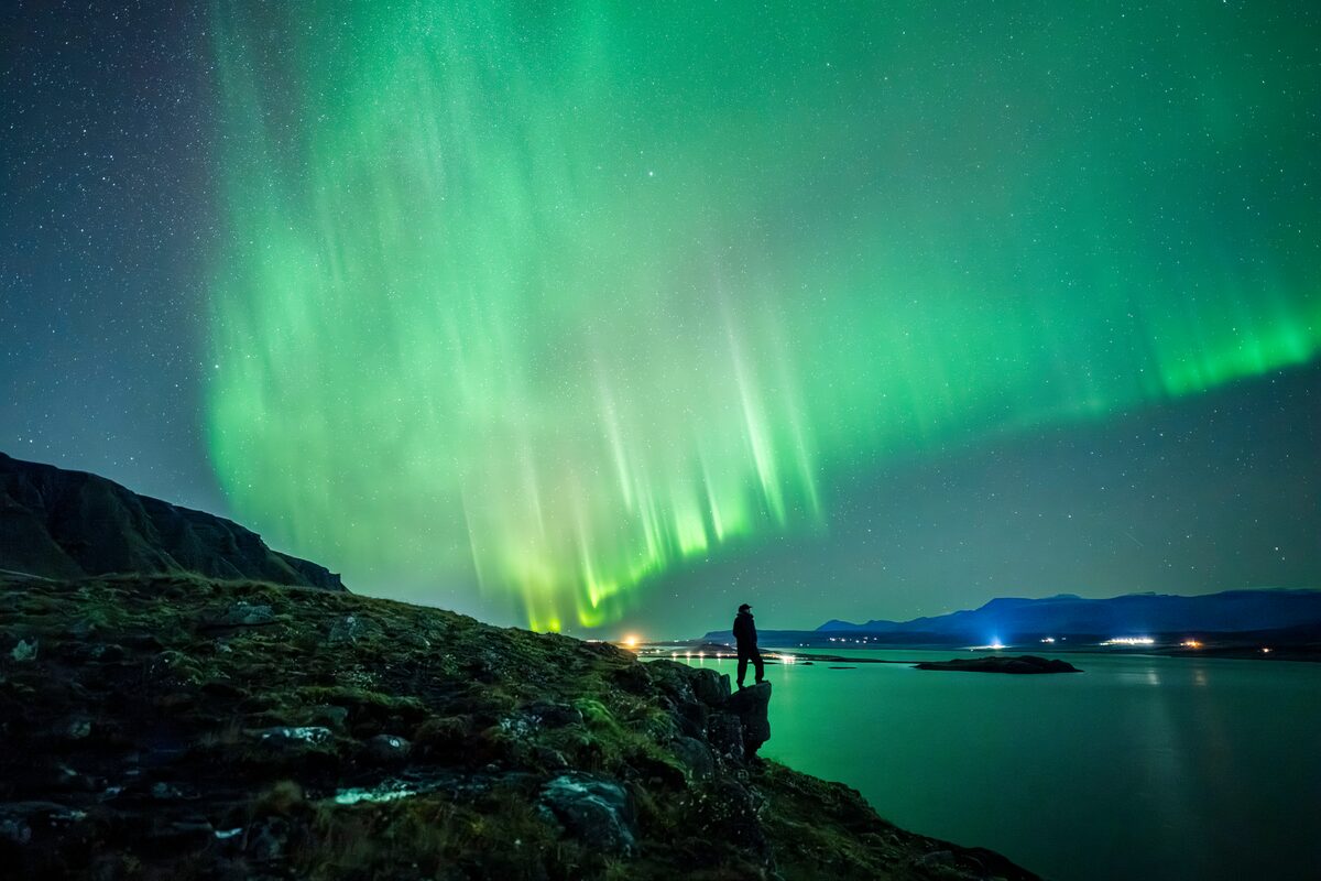 Person posed still under aurora, captured as a clean silhouette.
