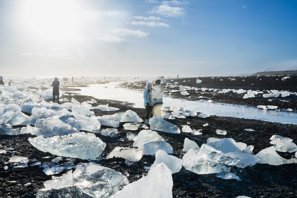 People near ice formations on Diamond Beach in Iceland.
