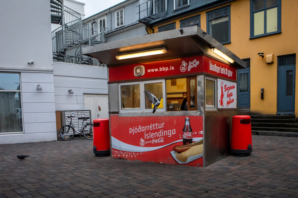 Bæjarins Beztu Pylsur hot dog stand in downtown Reykjavík, a small red kiosk on a paved street.