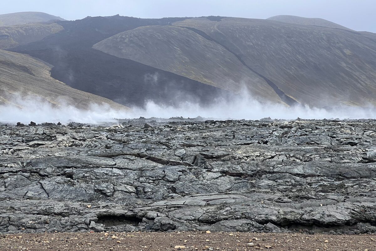 Smoking Lava Field With Hill In The Background in Iceland