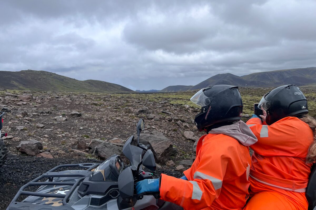 Two People On An Atv Looking At A Field in Iceland